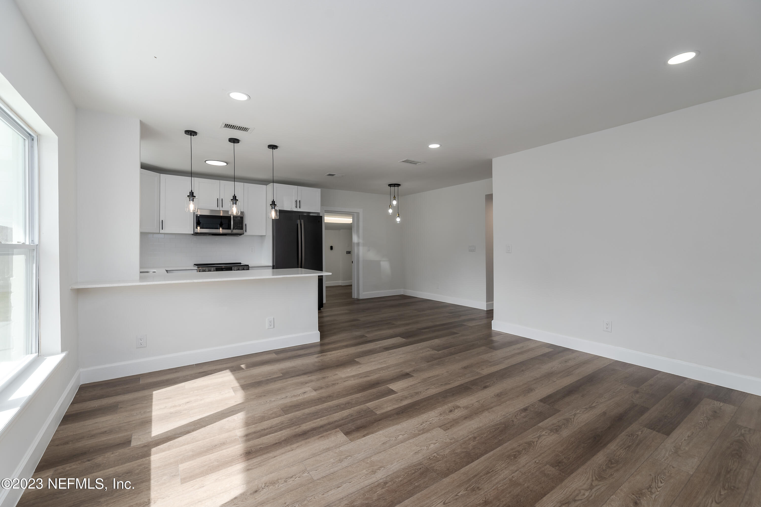 7425 Centauri Road Jacksonville, FL 32210 - Photo 4 of 23 a large kitchen with stainless steel appliances kitchen island a large counter top and a wooden floors