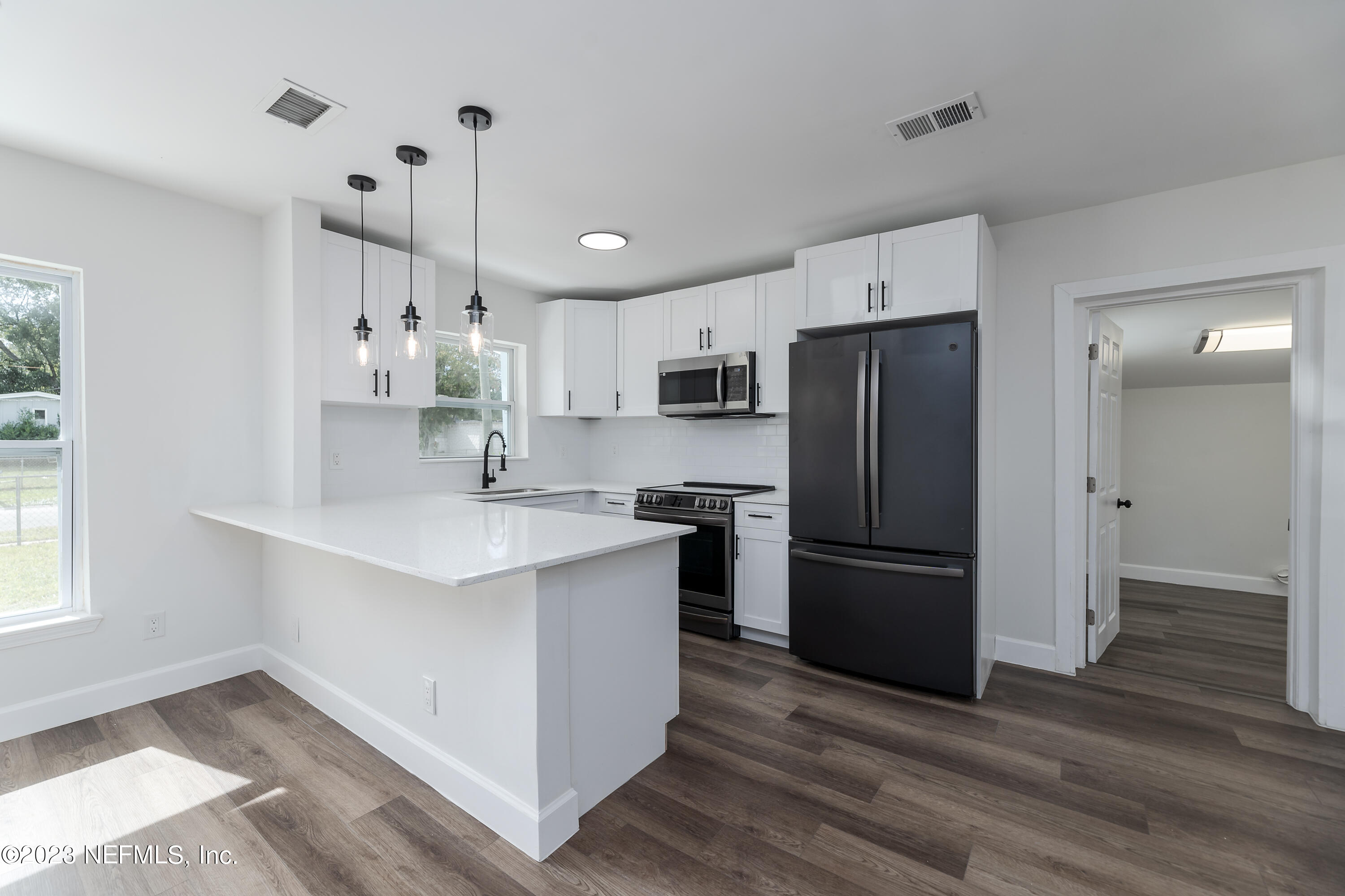 7425 Centauri Road Jacksonville, FL 32210 - Photo 6 of 23 a kitchen with kitchen island white cabinets and stainless steel appliances