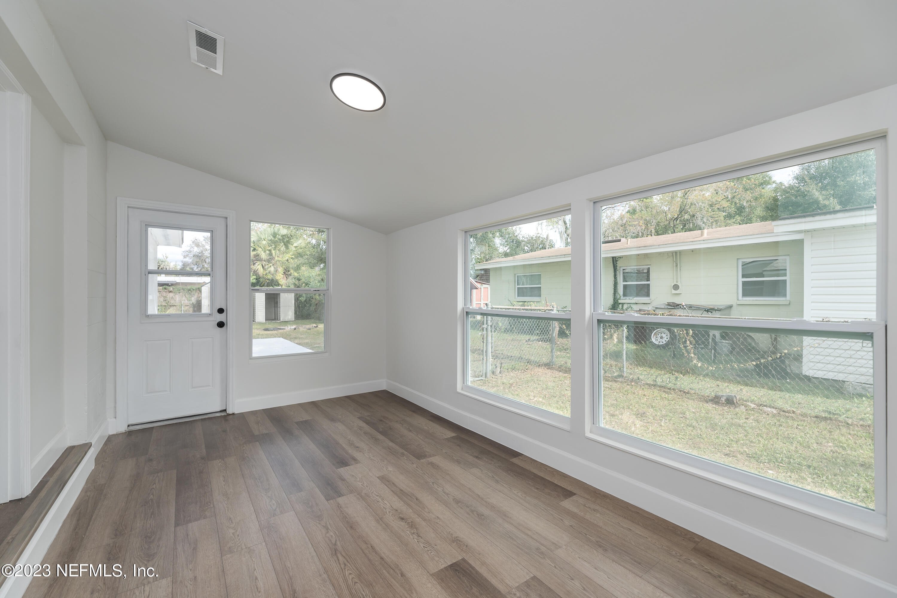 7425 Centauri Road Jacksonville, FL 32210 - Photo 10 of 23 an empty room with wooden floor and windows