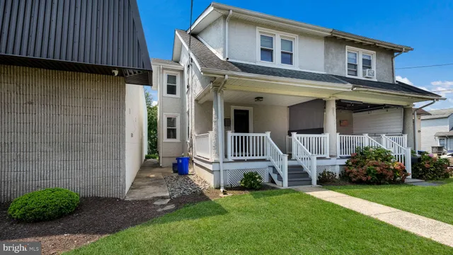 a front view of a house with a garden and plants
