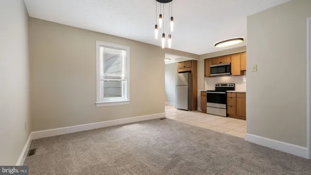 a view of kitchen with granite countertop cabinets and refrigerator