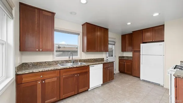 a kitchen with sink a refrigerator and cabinets