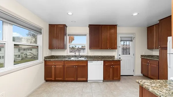 a kitchen with stainless steel appliances granite countertop wooden cabinets a sink and a stove
