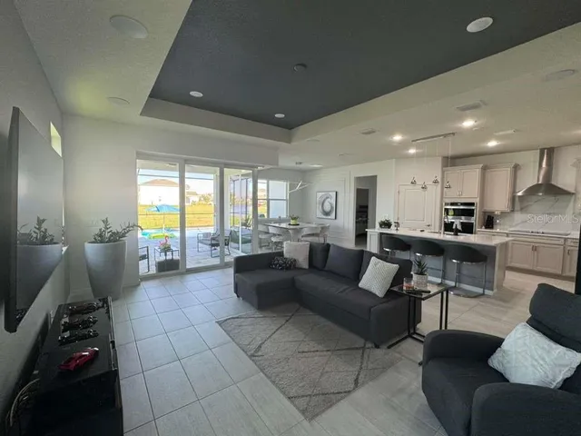 a living room with furniture and kitchen view