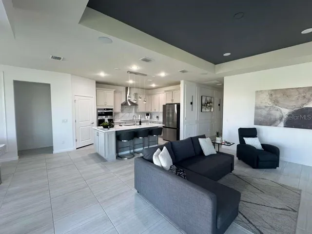 a living room with furniture and kitchen view