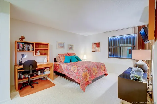 a bedroom with a bed and painting on the wall