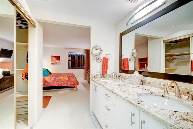 a spacious bathroom with a double vanity sink and a mirror
