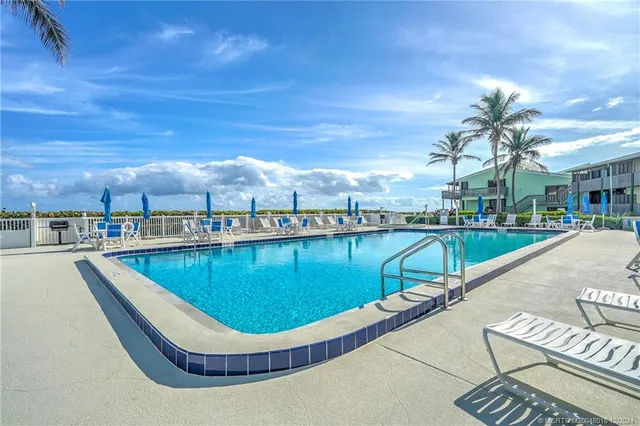 a view of a swimming pool with a table and chairs