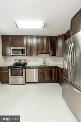 a kitchen with kitchen island stainless steel appliances a sink stove and refrigerator