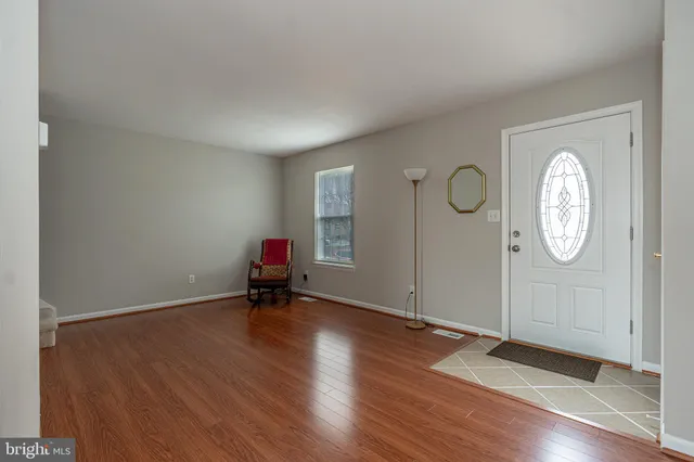 an empty room with wooden floor and mirror