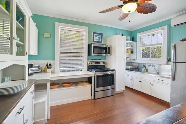 a kitchen with stainless steel appliances white cabinets a stove a sink and a refrigerator