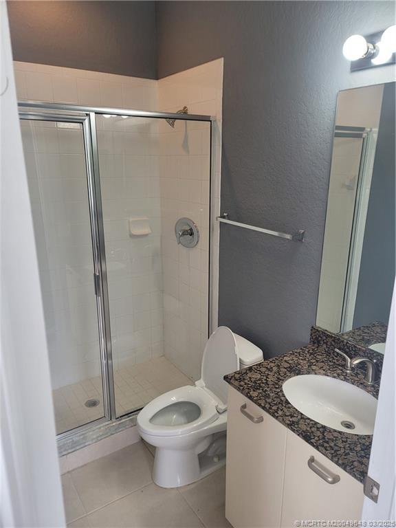 59 Southeast Palermo, Unit 204 Stuart, FL 34994 - Photo 11 of 23 a bathroom with a granite countertop sink toilet and shower