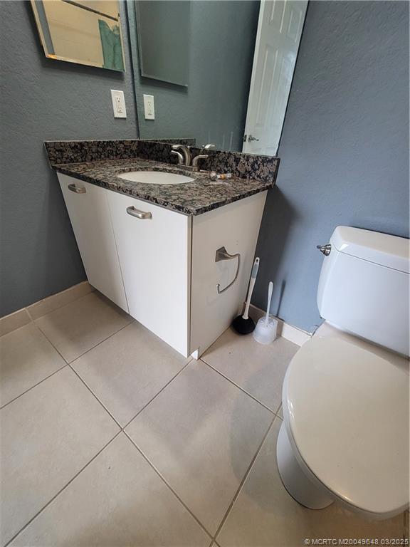 59 Southeast Palermo, Unit 204 Stuart, FL 34994 - Photo 17 of 23 a bathroom with a granite countertop sink and a toilet