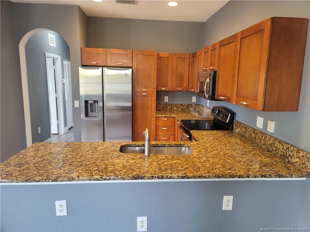 59 Southeast Palermo, Unit 204 Stuart, FL 34994 - Photo 4 of 23 a kitchen with stainless steel appliances granite countertop a refrigerator a stove and a sink