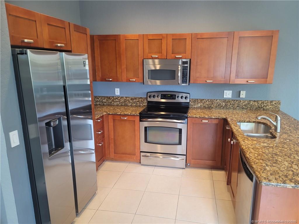 59 Southeast Palermo, Unit 204 Stuart, FL 34994 - Photo 5 of 23 a kitchen with stainless steel appliances granite countertop a refrigerator stove and sink