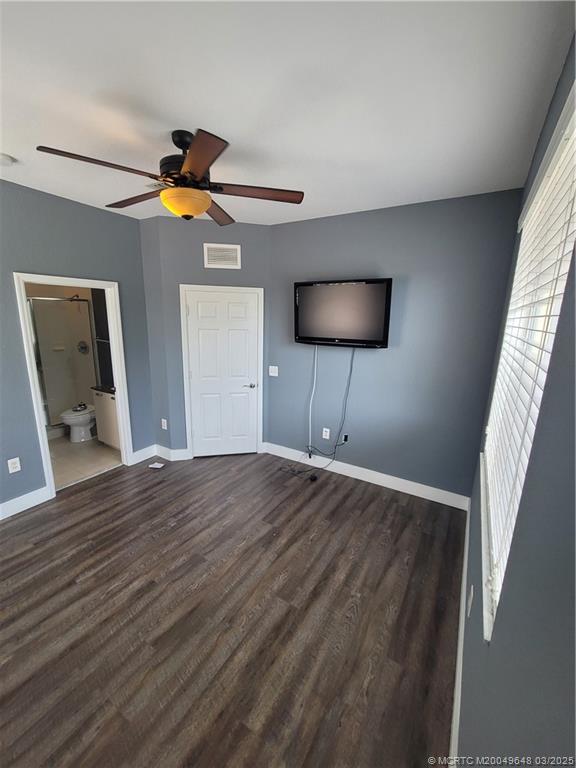 59 Southeast Palermo, Unit 204 Stuart, FL 34994 - Photo 9 of 23 a bedroom with a bed and a ceiling fan