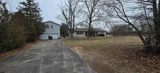a view of a house with a yard and trees