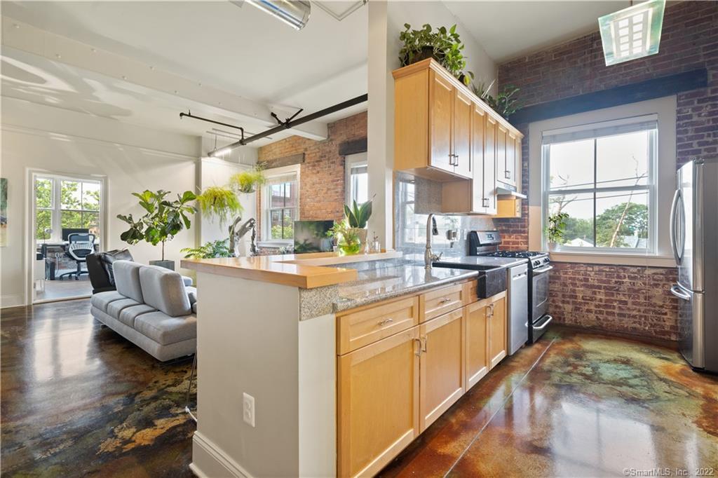 a open kitchen with stainless steel appliances granite countertop a stove a sink and a refrigerator