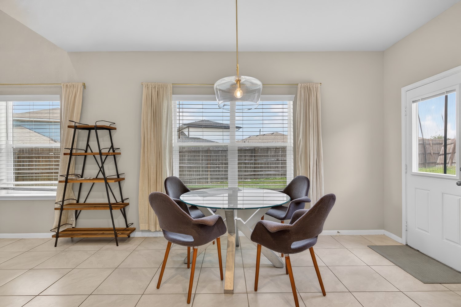 2006 Grow Lane Austin, TX 78754 - Photo 10 of 40 A well-lit dining area features tiled flooring, a clear glass table, and a contemporary pendant light.