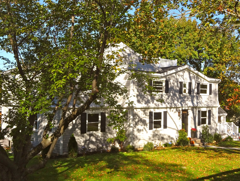 a front view of a house with a tree in it