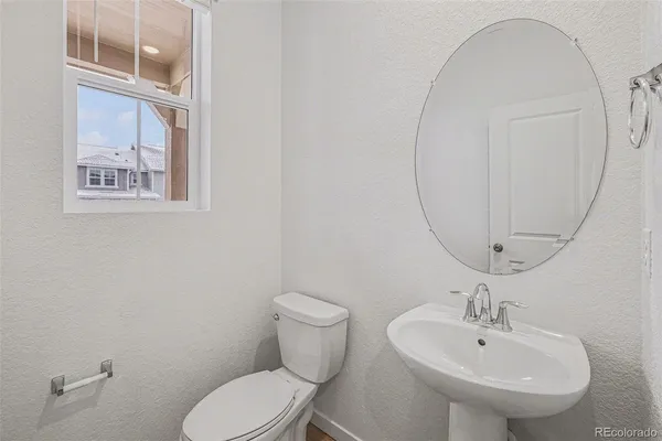 a bathroom with a toilet a sink and mirror