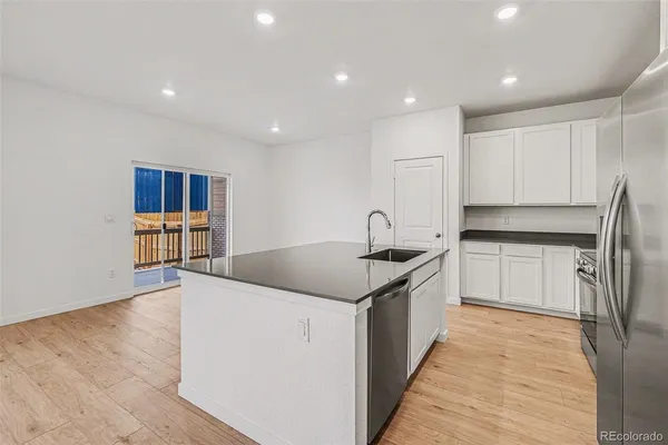 a kitchen with stainless steel appliances granite countertop a sink and a refrigerator