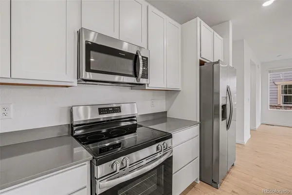 a kitchen with stainless steel appliances white cabinets and a stove top oven