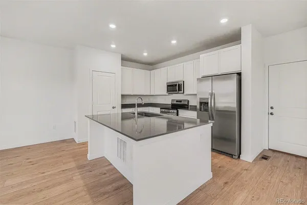 a kitchen with kitchen island a sink stainless steel appliances and refrigerator