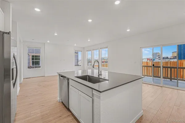 a kitchen with stainless steel appliances granite countertop a sink and a refrigerator