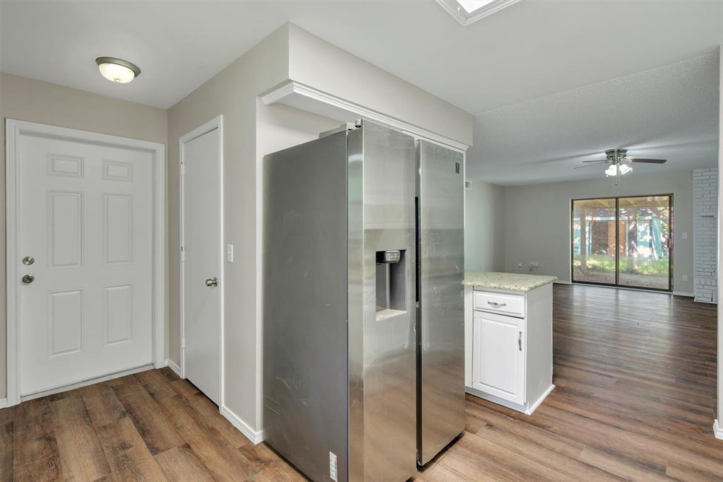 209 Mistletoe Lane Keene, TX 76059 - Photo 15 of 38 a view of a refrigerator in kitchen and wooden floor