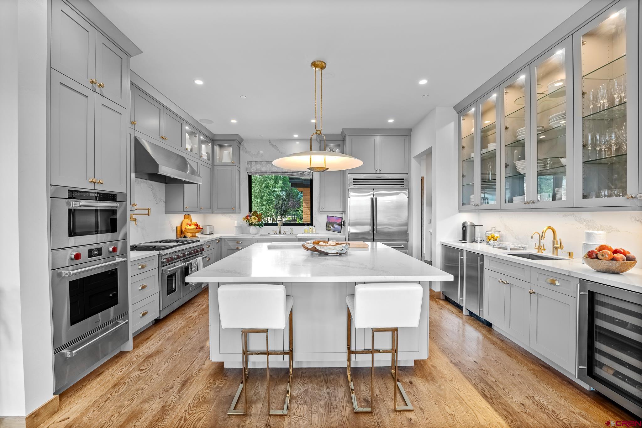 220 Hideout Trail Durango, CO 81301 - Photo 16 of 35 a kitchen with stainless steel appliances kitchen island granite countertop a stove a sink dishwasher and a refrigerator with wooden floor
