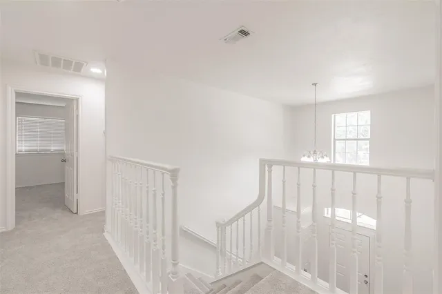 a view of staircase with white walls and fan