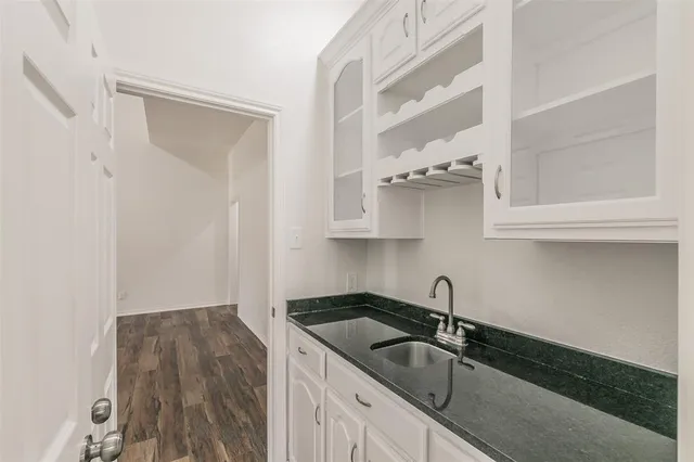 a kitchen with granite countertop a sink and cabinets
