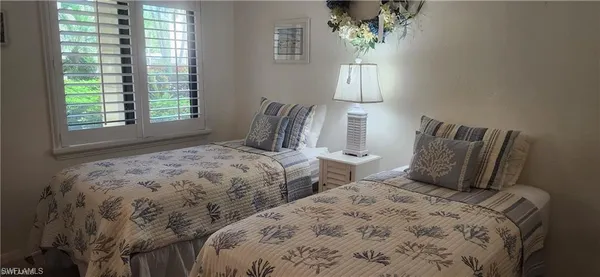 a bedroom with two beds and a window