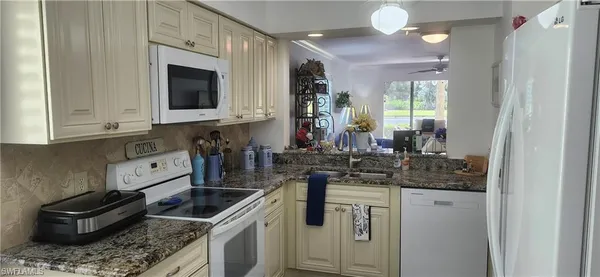 a kitchen with stainless steel appliances granite countertop a sink stove and cabinets