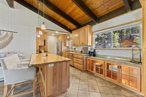 a large kitchen with stainless steel appliances granite countertop a sink and cabinets