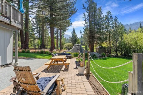 a view of a wooden chairs and fire pit in the backyard of a house