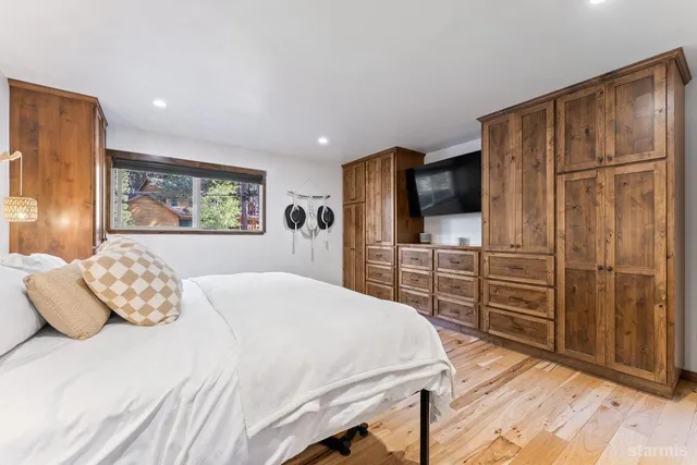 a bedroom with a large bed and wooden floor