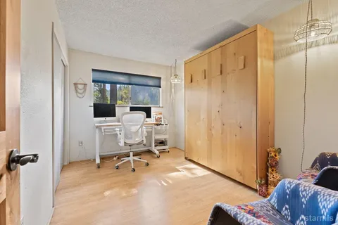 a view of a livingroom with workspace and a window