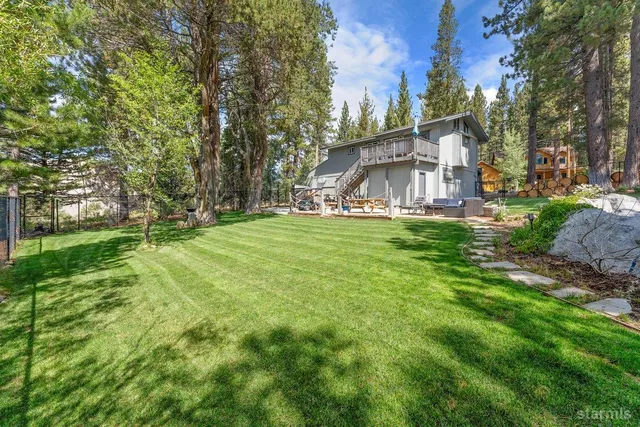 a view of a big house with a big yard and large trees