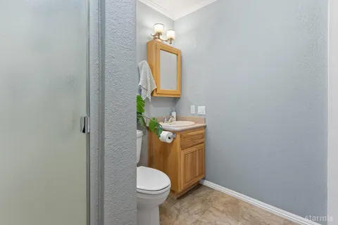 a bathroom with a toilet a sink and mirror