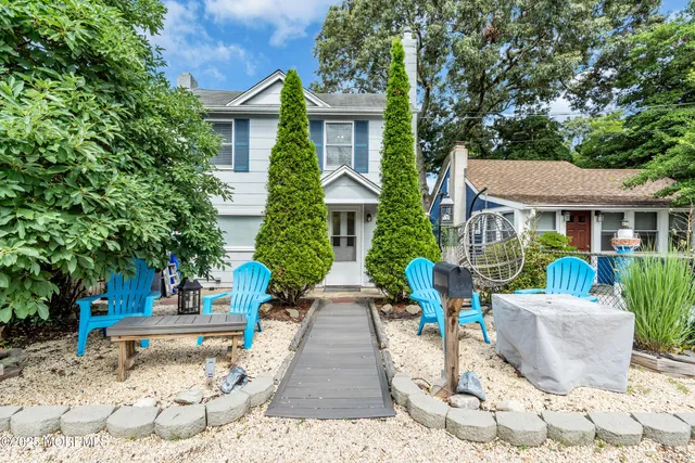 a view of brick house with a yard and plants
