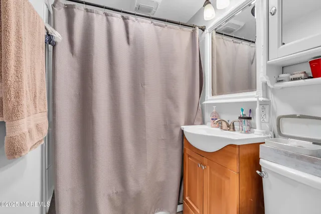 a bathroom with a sink a mirror and a shower curtain