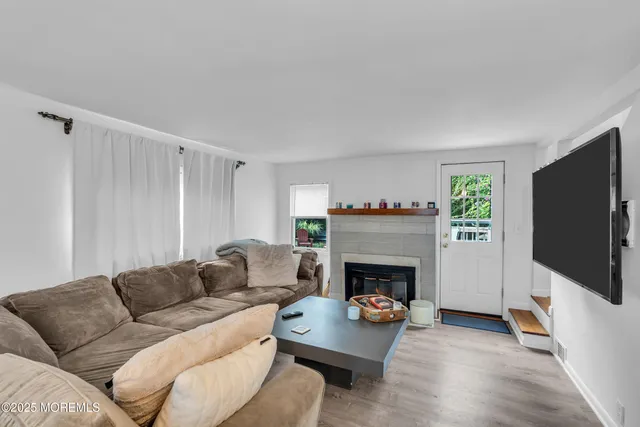 a living room with furniture a flat screen tv and a fireplace