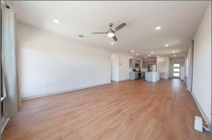 10805 Meris Lane Austin, TX 78754 - Photo 5 of 28 An open-concept living area flows seamlessly into the kitchen, illuminated by recessed lighting and a ceiling fan.
