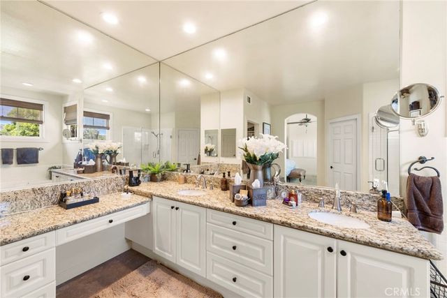 a bathroom with a granite countertop tub sink toilet and mirror
