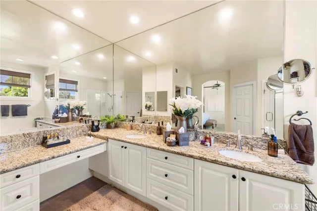 a bathroom with a granite countertop tub sink toilet and mirror