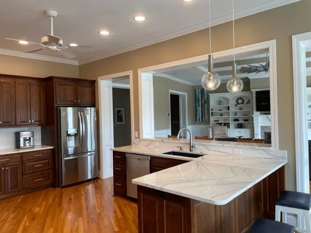 a kitchen with stainless steel appliances granite countertop a sink refrigerator and cabinets