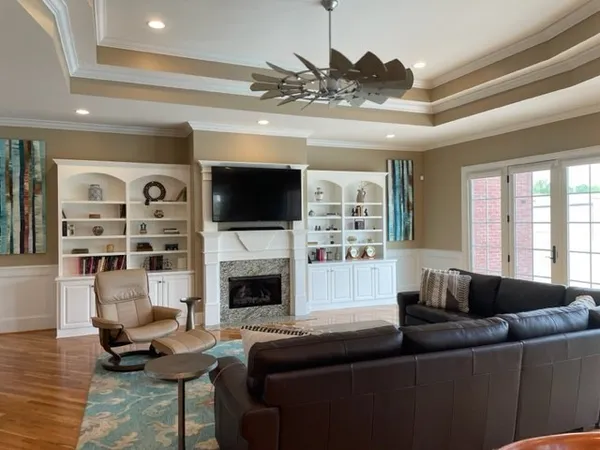 a kitchen with stainless steel appliances granite countertop a stove top oven a sink a dining table and chairs with wooden floor