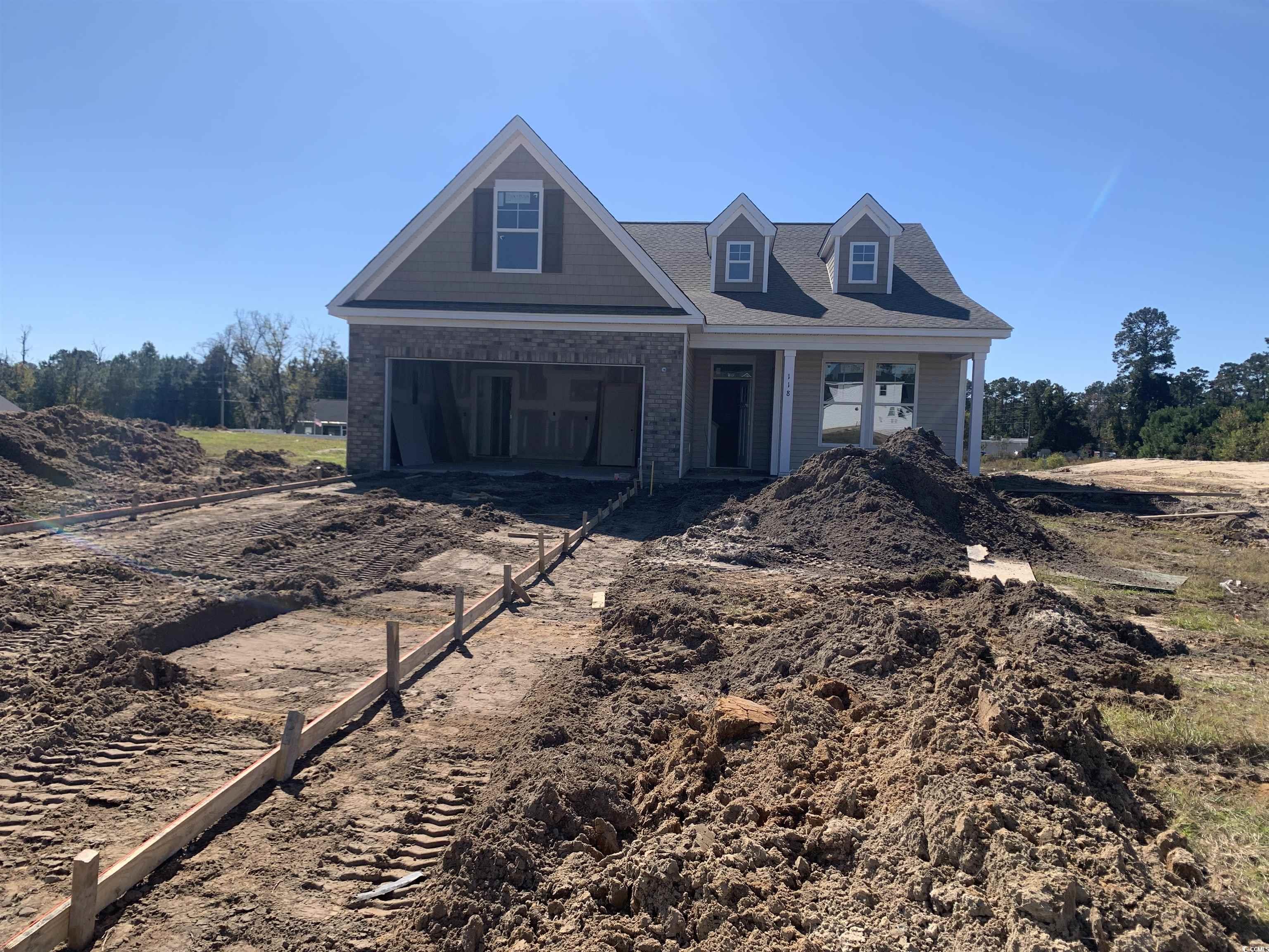View of front of house with brick siding, covered porch, driveway, and a garage